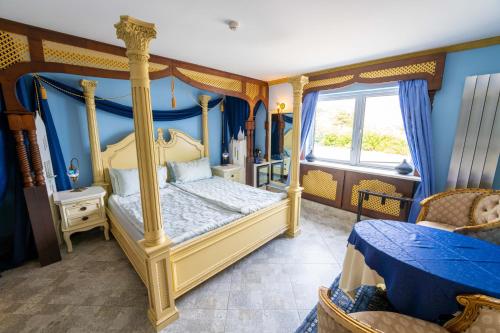 基尔芬代尔豪华精品住宿加早餐旅馆的一间卧室配有一张天蓬床和蓝色的墙壁