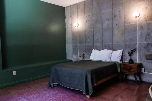 瓜达拉哈拉Casa Sabina的一间卧室设有一张床和绿色的墙壁