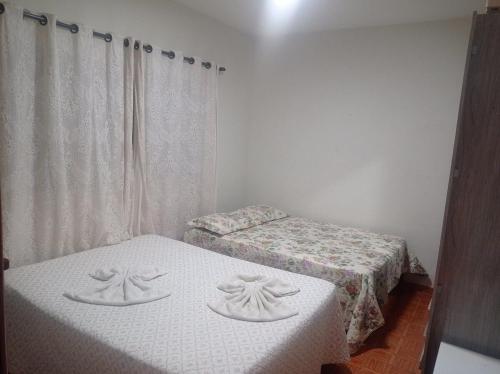 乌贝拉巴Casa Lá Vita的配有白色墙壁的小客房内的两张床