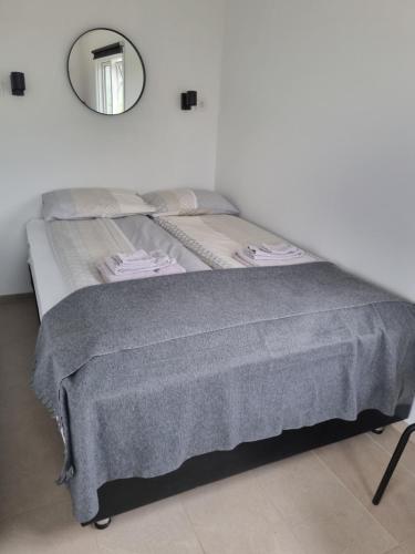 Hvammur 6 with private hot tub的一张带灰色毯子和镜子的床