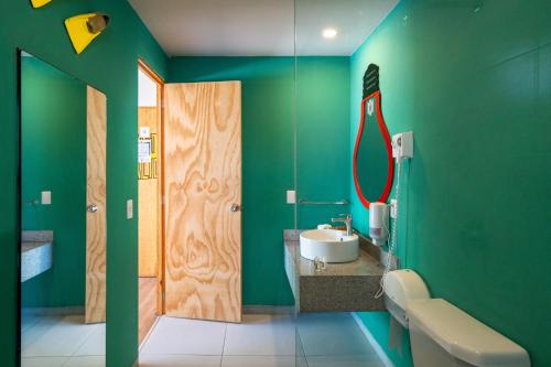坎昆Mayan Monkey Cancun的绿色浴室设有水槽和镜子