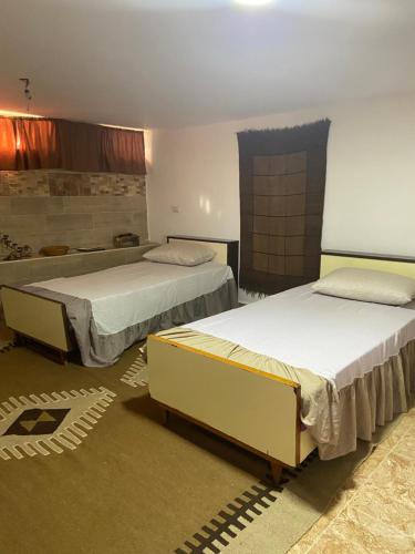 马达巴Simple home的一间客房内配有两张床的房间