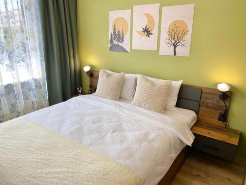 旧扎戈拉Colourful Apartment for 4 Guests and Free Parking的卧室配有白色的床,墙上挂着一些绘画作品