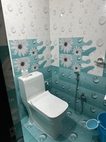 拉加蒙德里Sreenilayam Luxury Stay Homes的浴室配有卫生间,墙上挂有鲜花