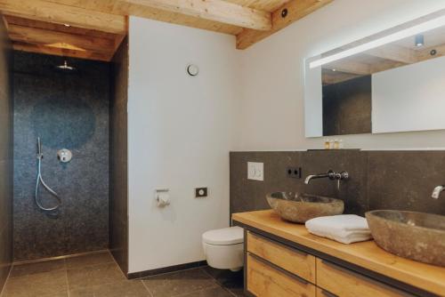奥夫特尔施旺Platzhirsch Ofterschwang的浴室设有木台上的两个盥洗盆