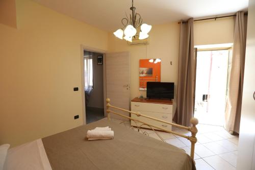 拉默齐亚泰尔默La casa di Bella的一间卧室设有一张床、一台电视和一个窗口。