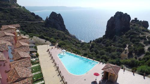 内比达L'Emozione Tanca Piras的享有游泳池的景色,背景是大海