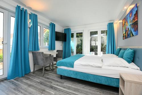 斯图加特City-Hotel Zuffenhausen的一间卧室配有蓝色窗帘、一张床和一张书桌