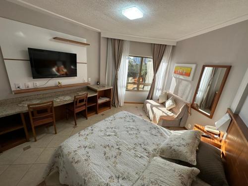 弗洛里亚诺波利斯Apartamento executivo的一间卧室配有一张床、一张书桌和一台电视