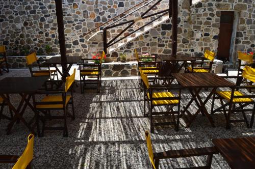 Mandrákion罗曼特佐旅馆的一间空餐厅,配有木桌和黄色椅子