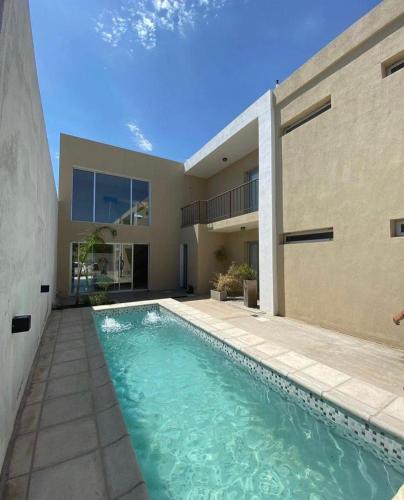 库拉布罗切罗镇Cañas Suites Villa Cura Brochero的房屋前的游泳池