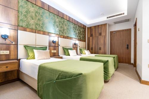 伊斯坦布尔Mardy Suit Hotel的配有绿床单的客房内的两张床