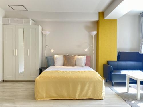 大阪ffosaka.com的一间卧室配有一张床和一张蓝色的沙发