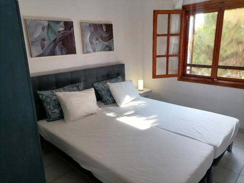 尼基季Pine & sea house的卧室配有一张带白色床单和枕头的大床。