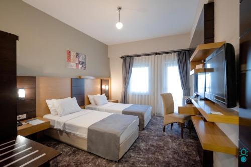 特拉布宗KTÜ Koru Otel的酒店客房设有两张床和一台平面电视。