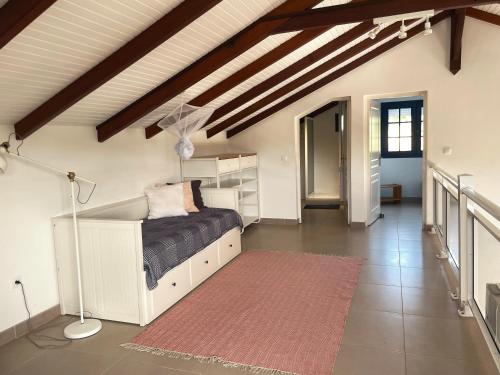 圣吕斯Villa Stone pour 8 personnes, piscine chauffée, accès PMR, 5 étoiles的卧室配有白色的床和红色地毯。