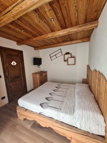 巴多尼奇亚La Maison. La Roccia dello Stambecco的木天花板的客房内的一张床位