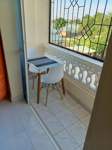 蒙巴萨ROYAL APARTMENT MAKUPA的窗户房间里一张桌子和一把椅子