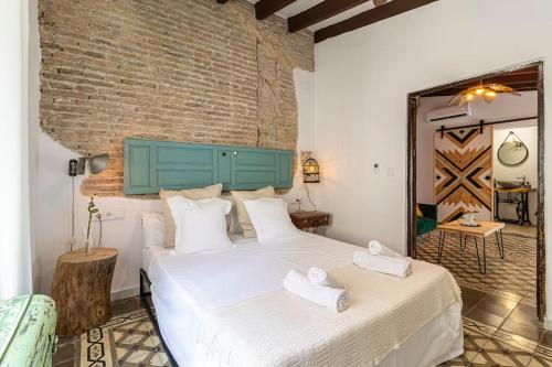 赫雷斯-德拉弗龙特拉Kala Ático - Apartamento Centro Jerez的一间卧室设有一张大床和砖墙