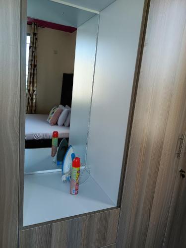 蒙巴萨ROYAL APARTMENT MAKUPA的镜子反射着卧室,卧室里有一张床