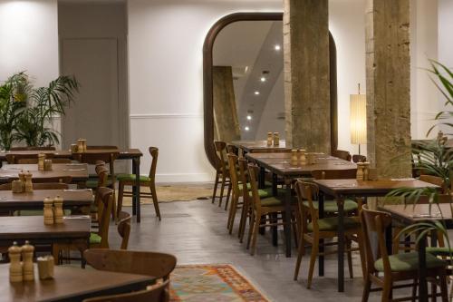 马德里7岛酒店的餐厅设有桌椅和大镜子