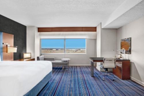 欧文DFW机场君悦酒店的酒店客房设有一张大床和一张书桌。