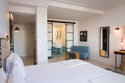 马德里7岛酒店的卧室配有白色的床和蓝色椅子