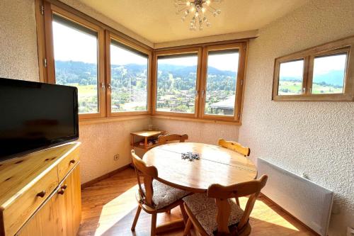 代米考迪亚Bright studio with view of Aiguille Verte的一间带桌子、电视和窗户的用餐室