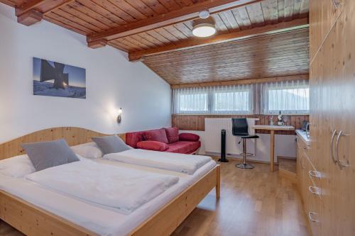 特洛普拉赫歇尔布劳尔公寓的一间卧室配有一张大床和一张红色的沙发