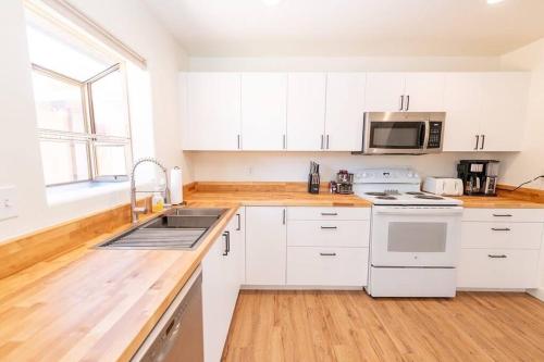 佩吉Newly Remodeled Family Friendly Home的厨房配有白色橱柜和水槽
