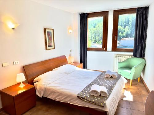 巴多尼奇亚[Paradiso di Montagna sulle piste da sci]的卧室配有床、椅子和窗户。
