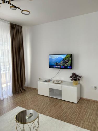 克拉多沃BB Apartment的一间客厅,在白色的墙上配有电视