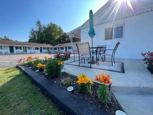 圣伊尼亚斯Cedars Motel的庭院配有桌椅和鲜花