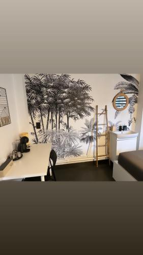 巴斯托涅La villa Bastogne chambre d'hôtes 2的一间设有书桌的客房,墙上种植了棕榈树