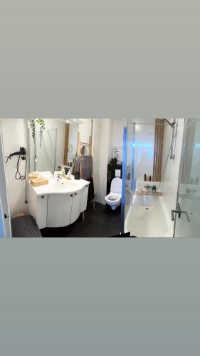 巴斯托涅La villa Bastogne chambre d'hôtes 2的浴室两张图片,配有浴缸和水槽