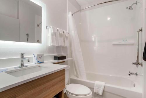 德斯坦Comfort Inn & Suites Destin near Henderson Beach的白色的浴室设有水槽、浴缸和卫生间。