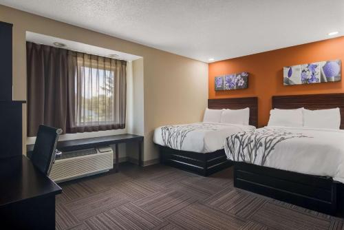 伊利Sleep Inn的酒店客房设有两张床和窗户。