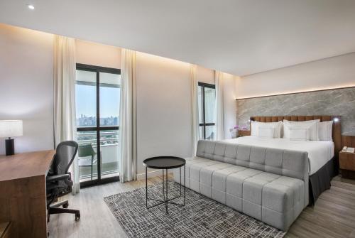圣保罗欧罗巴花园美利亚酒店的酒店客房设有一张大床和一张书桌。