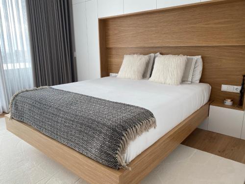 维亚纳堡PEARL by Balgrid的一间卧室配有一张大床和木制床头板