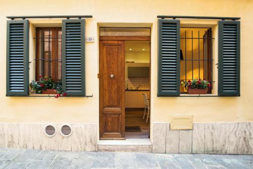 锡耶纳Magione 10的一座带蓝色百叶窗和木门的房子