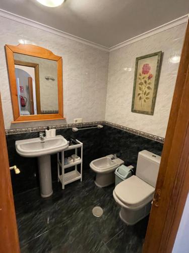 利亚内斯Apartamentos Los Cubos de Llanes 3的一间带水槽、卫生间和镜子的浴室