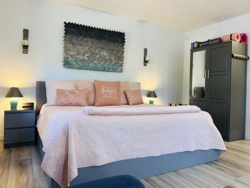 塞多纳SALE Artsy Casita, King Bed, Walk 2 Trails & Food, Mountain Views, Trail Pass的卧室配有一张带粉红色枕头的大床