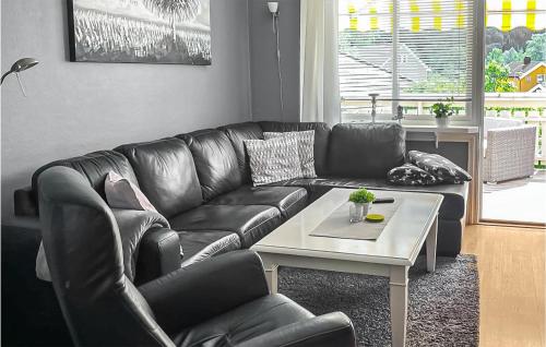 尤坎2 Bedroom Amazing Apartment In Rjukan的客厅里一张黑色皮沙发,配有桌子