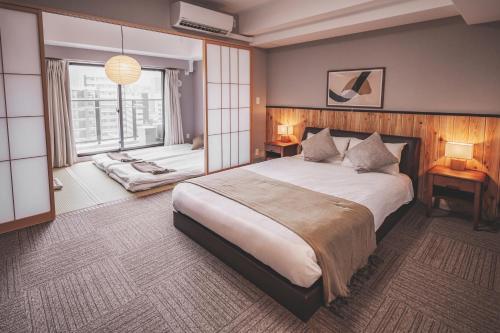 大阪川House道頓堀的一间卧室设有一张大床和一个窗户。