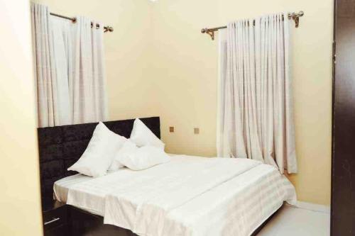 奥韦里Cityflats Apartment的卧室内的白色床和白色枕头