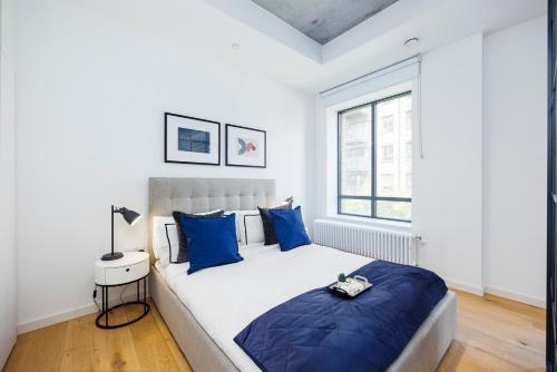 伦敦Apartment Near Canary Wharf 02 Arena & Excel的一间卧室配有一张带蓝色枕头的大床