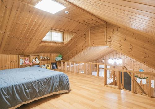 济州市济州哈普达尔旅馆的卧室配有木制天花板上的床铺