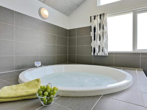 博恩瑟Holiday home Bogense XLII的地板上带葡萄的浴室内的大浴缸