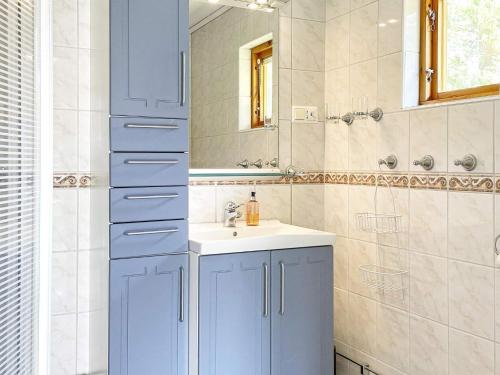 RejmyreHoliday home Rejmyre II的一间带蓝色橱柜和水槽的浴室