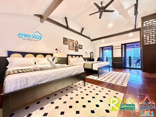 马六甲Wayfarer Guest House Jonker Street Melaka By Heystay Management的一间卧室配有两张床和吊扇